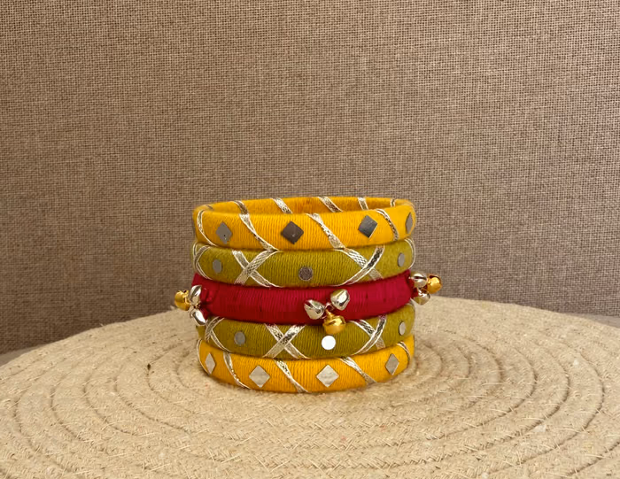 Kesar yellow and pink handmade festive thread bangle set with metallic detailing by Kruki Dooki